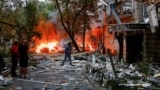 Киевляне возле разрушенного во время российской атаки дома. 31 июля 2025 года